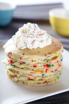 a piece of cake with sprinkles is on a plate next to a bowl