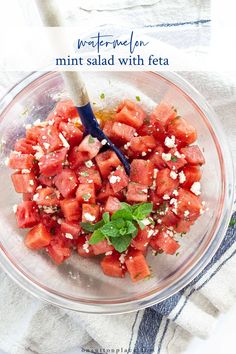 watermelon salad with feta in a glass bowl on top of a towel