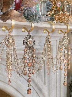 a fireplace mantel decorated with gold and crystal jewelry hanging from it's sides