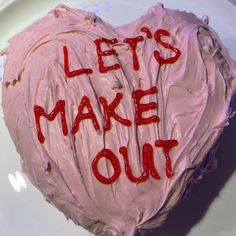 a heart shaped cake with the words let's make out written on it