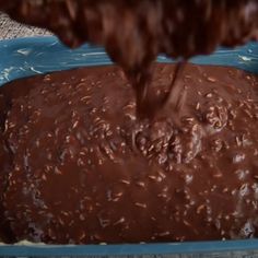 someone is pouring chocolate into a blue dish