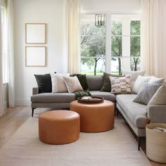 a living room filled with lots of furniture next to a large window covered in white curtains