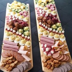 two platters filled with meats and cheeses on top of eachother