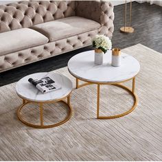 two tables sitting on top of a rug in front of a couch and coffee table