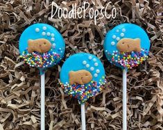 three blue cake pops decorated with dog food and sprinkles