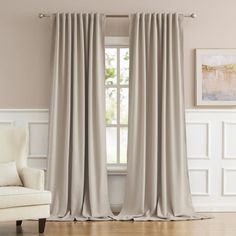 a living room with white walls and beige curtains