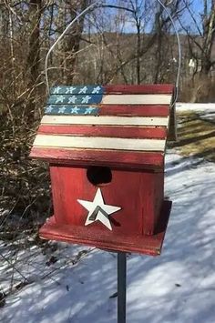 an american flag birdhouse is shown in the snow