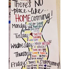 there is no place like home coming poster hanging on the wall in front of bookshelves