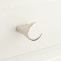 a close up of a knob on a white cabinet