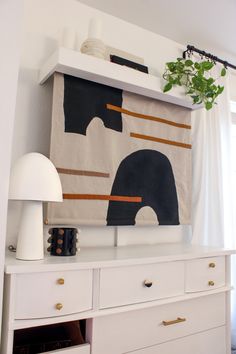 a white dresser with an elephant painting on it