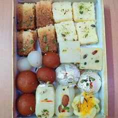 an open box filled with different types of food on top of a wooden table,