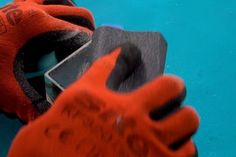 a pair of red work gloves on top of a piece of metal