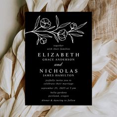 a black and white wedding card with flowers on it