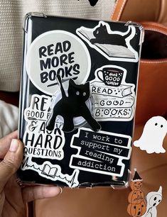 a person holding up a book with stickers on it