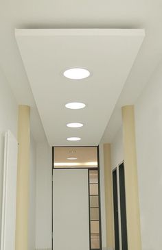 an empty hallway with several lights on the ceiling