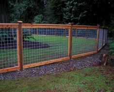 the fence is made of wood and has metal bars on each side, along with gravel