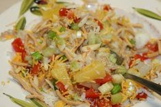 a white plate topped with lots of different types of food next to a fork and knife