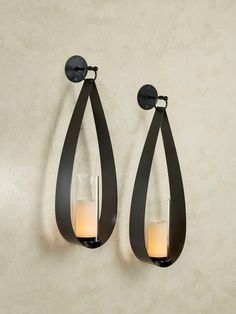 two candle holders are hanging on the wall