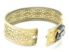 "Beautiful gold filigree bracelet made by Plainville Stock Company in the 1930s. The front panel features a black onyx ellipse set with rhinestones. This is a common theme for mourning jewelry, as it signified \"a light in the darkness\" and was intended to give comfort to the bereaved. I think the sentiment is meaningful even for those who have not lost a loved one, and can be a reminder of goals and important life motifs. CONDITION/SIZE: Good vintage condition - some finish loss which is reall Antique Gold Bracelets For Vintage Events, Adjustable Ornate Bangle For Formal Occasions, Antique Bracelet For Evening Wear, Vintage Bangle With Decorative Band, Ornate Hinged Bracelets For Wedding, Formal Filigree Bangle Jewelry, Ornate Hinged Bracelets For Formal Occasions, Vintage Formal Bangle Hand Set, Vintage Bangle Cuff Bracelet For Evening