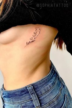 a woman's stomach with the word love tattooed on her lower side ribcage