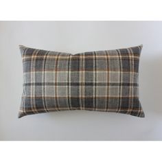 a gray plaid pillow sitting on top of a white wall