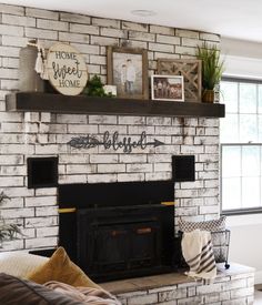 a brick fireplace in a living room with pictures on the mantle and other decorations above it