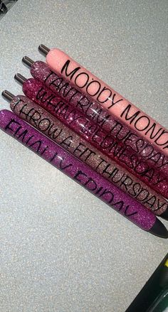 three lip glosses sitting next to each other on top of a table with writing on them