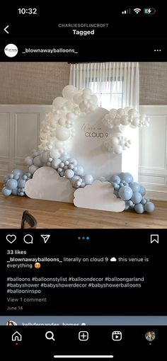 a white and blue balloon arch in the middle of a room