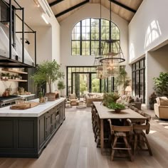 a large open concept kitchen and dining room with wood flooring, high vaulted ceilings