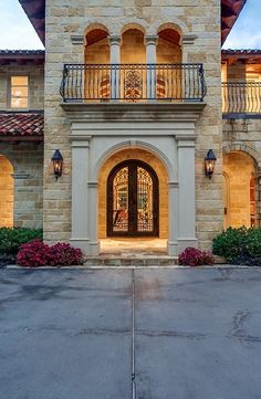 the front entrance to a large home with two balconies and an iron railing