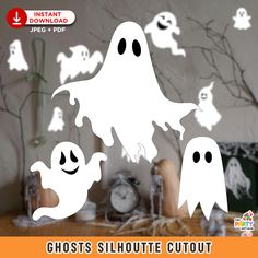 ghost silhouette cutouts for halloween decorations on a table