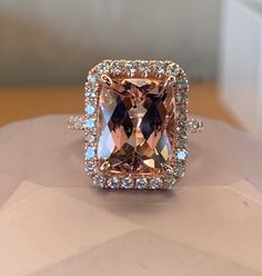 a fancy ring with an orange and blue stone surrounded by white topazs on display