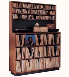 an old record player is sitting in front of a bookcase filled with vinyl records