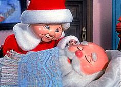 a santa clause is laying in bed with a baby