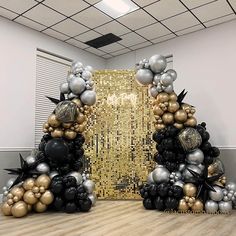 two black and gold balloons are stacked on top of each other in the shape of a christmas tree