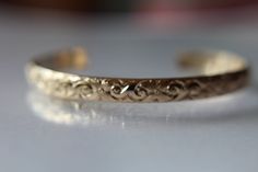 "This stunning bracelet is 14 karat gold filled made with nice wide and thick 6.40mm x 1.68mm . It is embossed with a pretty swirls and blooms pattern. This wonderful whimsical wire I form into a cuff, file each end, and finally polished using a machine to a high shine. Really pretty alone or stacked with other cuffs. You can get this personalized please select from the drop down. Xsmall-2 Inches Diameter-Wrist Circumference 5-6 Inches Small-2.25 Inches Diameter-Wrist Circumference 6-7 Inches Me Cuff Bracelet Gold, Boho Cuff Bracelet, Floral Cuff, Boho Cuff, Gold Armband, Gold Bracelet Cuff, Initial Ring, Black Gift Boxes, Bracelet Cuff