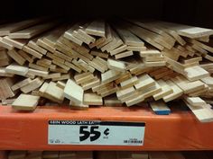 a pile of wood sitting on top of a orange shelf next to other wooden planks