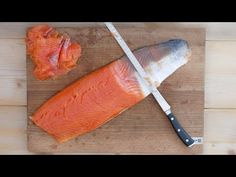 a piece of salmon on a cutting board with a knife