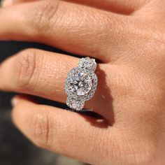 a woman's hand with a diamond ring on top of her finger and an engagement band