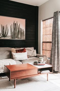 a living room with a couch, coffee table and painting on the wall above it