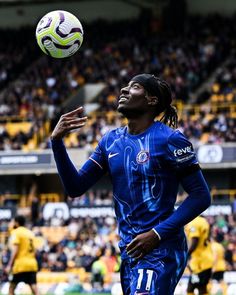 a soccer player is in mid air with the ball above his head as he prepares to kick it