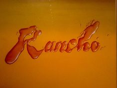 the word rancho written in orange liquid on a yellow background