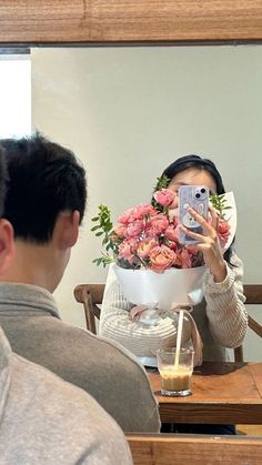 a woman taking a selfie in front of a mirror with flowers on her head