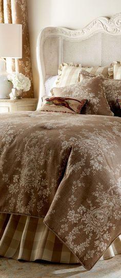 a bed with brown and white comforters in a bedroom