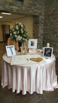 the table is set up with pictures and flowers in vases for guests to sign