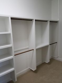 an empty room with white shelves and no one is in the photo or there is also a door