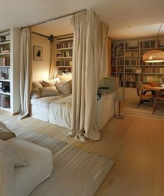 a bedroom with white furniture and lots of bookshelves in the room, including a bed