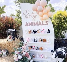 there is a sign with animals on it and balloons in the air above it that says party animals