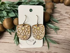 Brighten up your accessory collection with these stunning Handmade Wood Engraved and Hand Painted Daisy Earrings. Each pair features a unique U-shaped design, intricately engraved with daisy patterns and hand painted to bring the flowers to life. Crafted from high-quality wood, these lightweight earrings are perfect for everyday wear or special occasions. The beautiful floral design adds a touch of boho charm, making them a versatile addition to any outfit. Whether you're gifting a loved one or Fall Floral Earrings, Wooden Flower Earrings, Adjustable Cream Drop Earrings, Handmade Cream Earrings As A Gift, Handmade Cream Earrings For Gift, Vintage Etched Earrings As Gift, Cream Bohemian Earrings As Gift, Cream Bohemian Earrings As A Gift, Cream Earrings With Ear Wire For Gifts