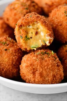 a white bowl filled with fried food covered in cheese and seasoning sitting on top of a table